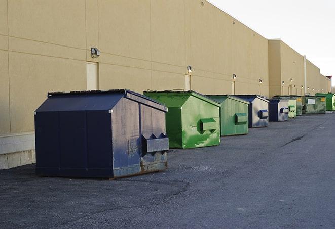 a pile of demolition waste sits beside a dumpster in a parking lot in Clark, CO